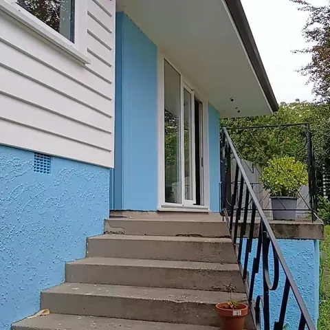 Repainted weatherboard house with rebuilt entry stairs