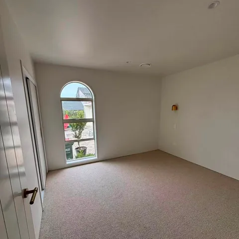 Room with an arched window and freshly laid carpet