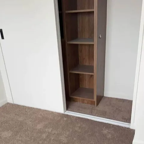 Built-in timber shelving unit fitted into an alcove